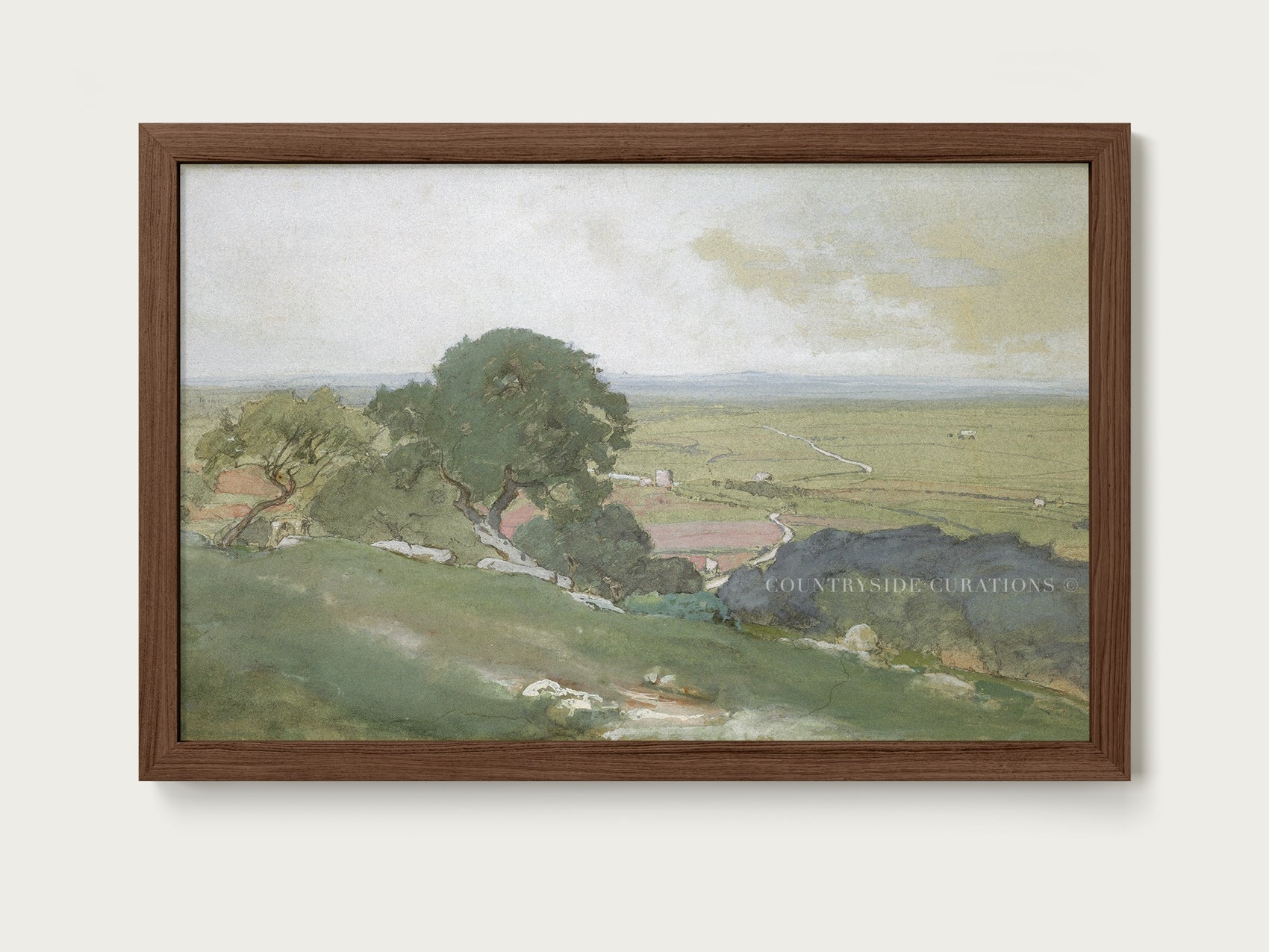 Walnut Framed painting of a landscape with green fields and trees on a white wall.