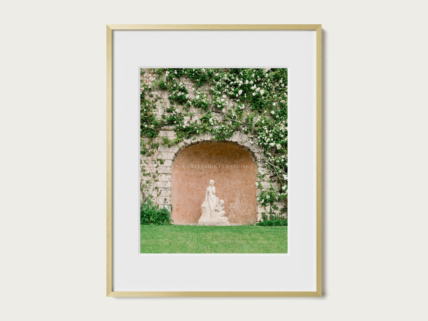 European courtyard photograph of a classical statue within a textured stone alcove covered in climbing plants.
