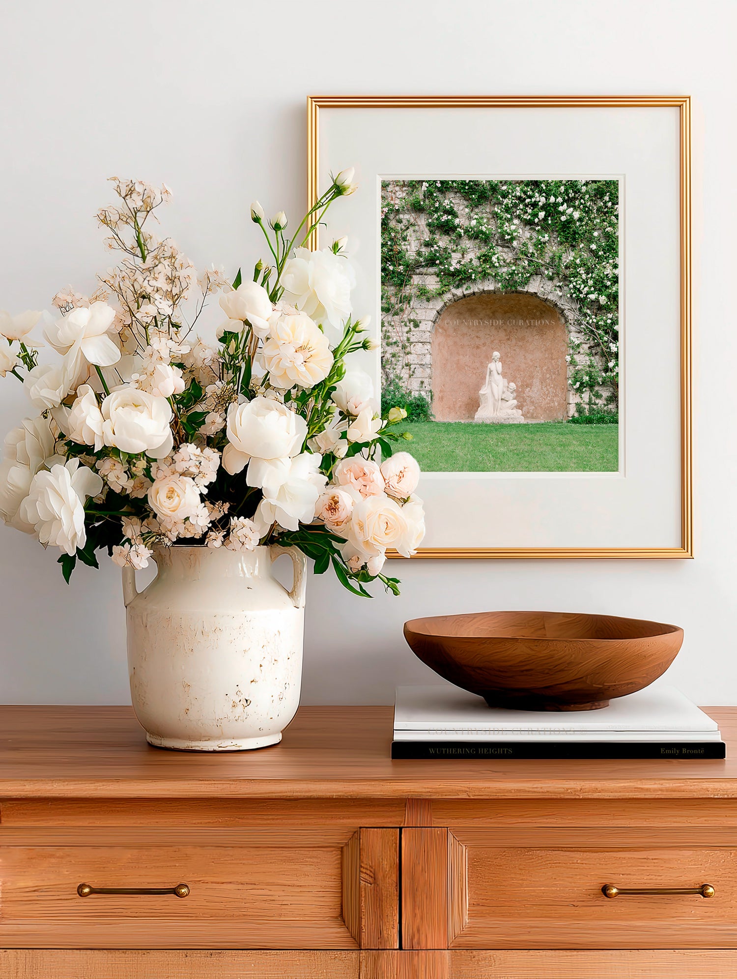 Feminine garden wall art showing a statue beneath an arched stone wall with greenery and soft tones.